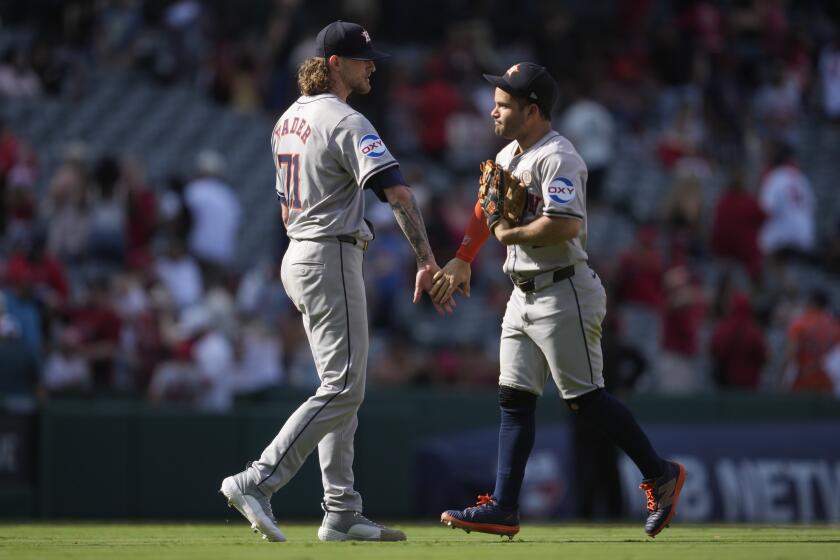 El lanzador abridor de los Astros de Houston, Josh Hader (71), y el segunda base José Altuve celebran después de una victoria por 6-4 sobre los Angelinos de Los Ángeles en Anaheim, California, el domingo 15 de septiembre de 2024. (AP Foto/Ashley Landis)