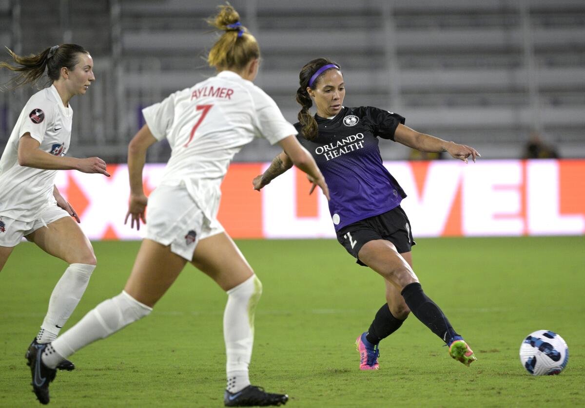 Orlando Pride forward Sydney Leroux passes a ball in front of Washington Spirit's Dorian Bailey, left, and Taylor Aylmer