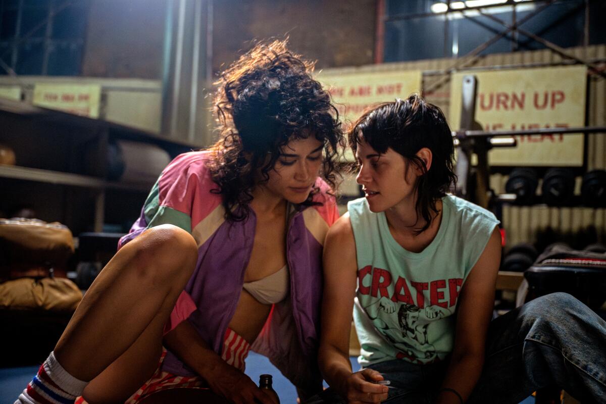 Two women sit next to each other in a gym.