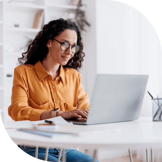 A woman sitting at a table with a laptop.