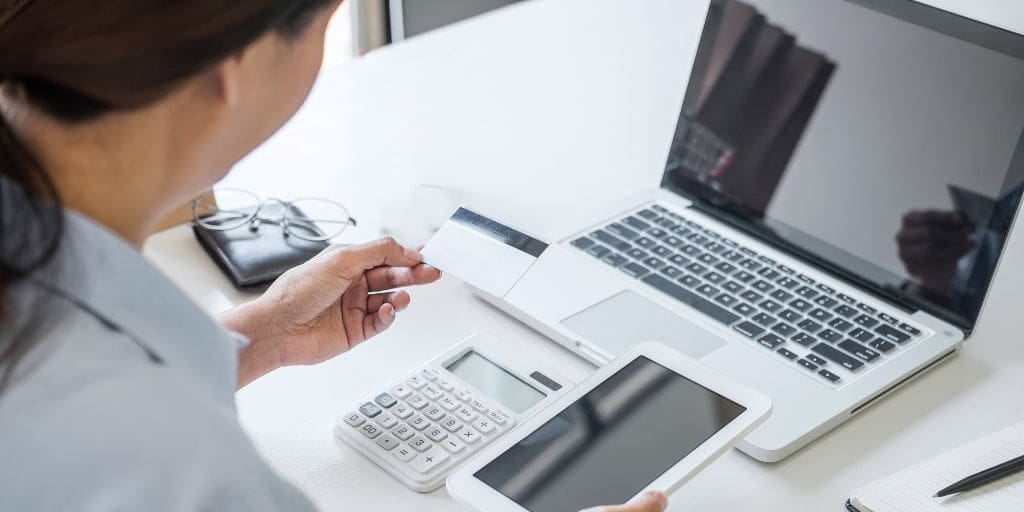 A woman using a laptop and a credit card.