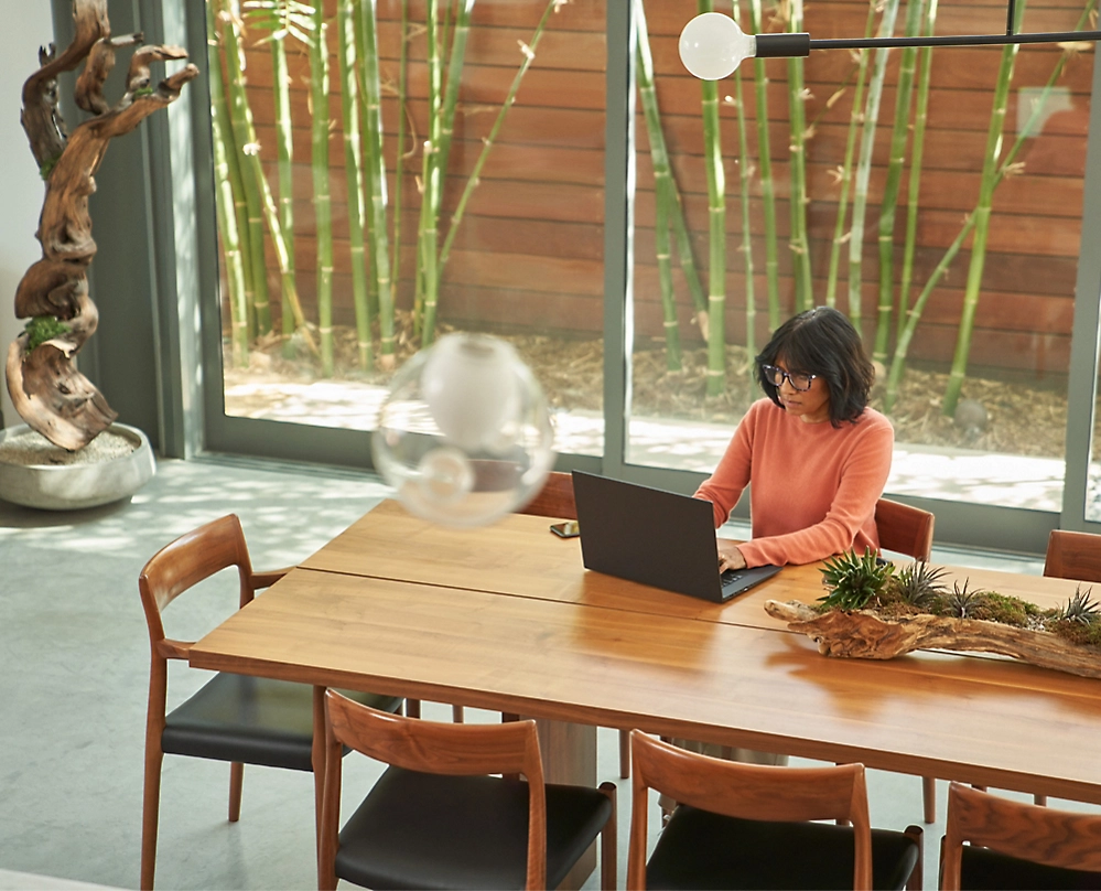 A person sitting at a table using a laptop