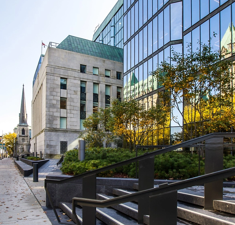 Paisaje urbano moderno con un edificio de cristal y piedra con un paisaje histórico visible en el fondo