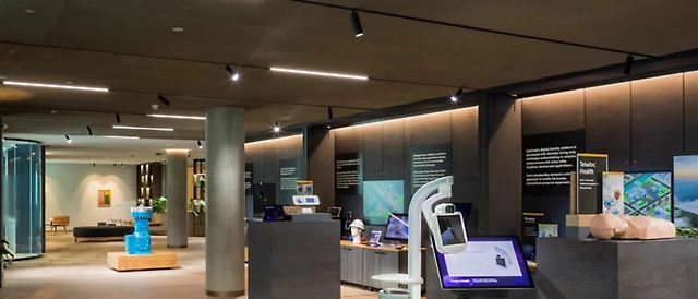 Interior de una exposición moderna de un jurado con pantallas interactivas, paneles informativos y elementos de diseño elegantes.