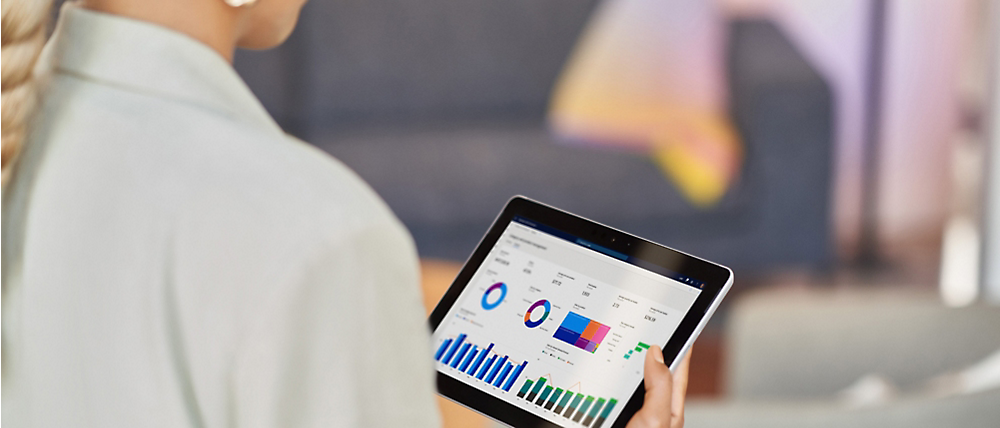 Persona sosteniendo una tableta que muestra gráficos coloridos, que indican el análisis de datos o las métricas empresariales.
