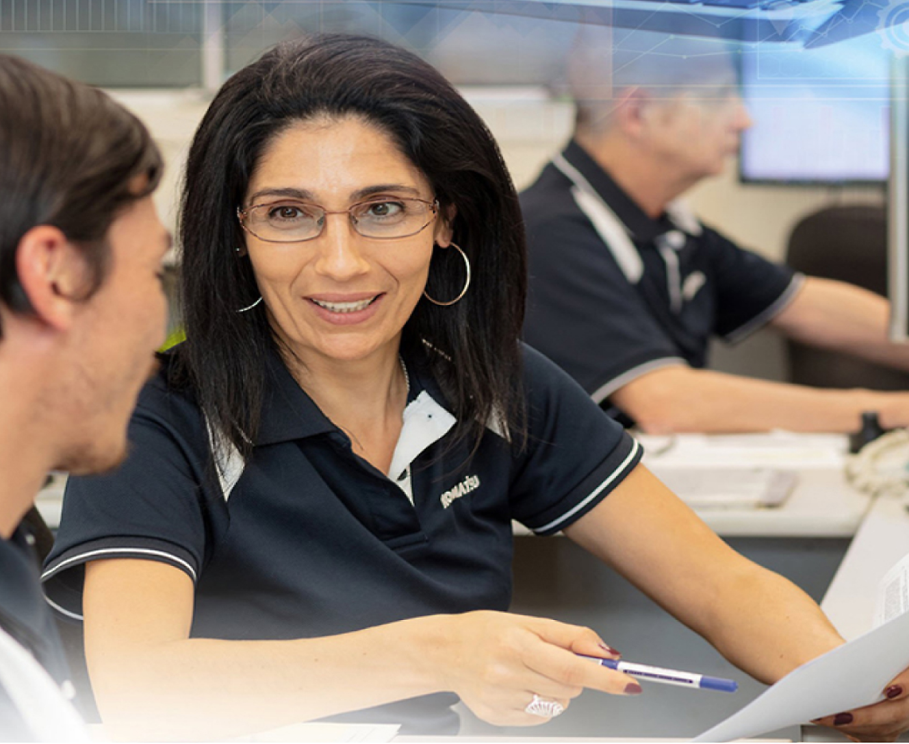 Grupo de personas sentadas en un escritorio en una oficina.