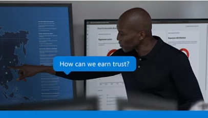 A man points to a digital world map on a screen, with the question "How can we earn trust?" displayed.