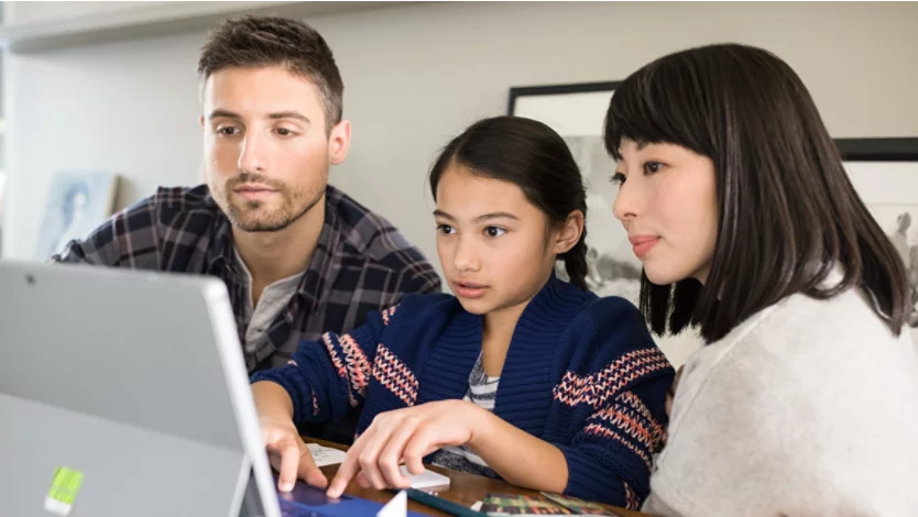 A family of three using a Surface 2-in-1 PC together