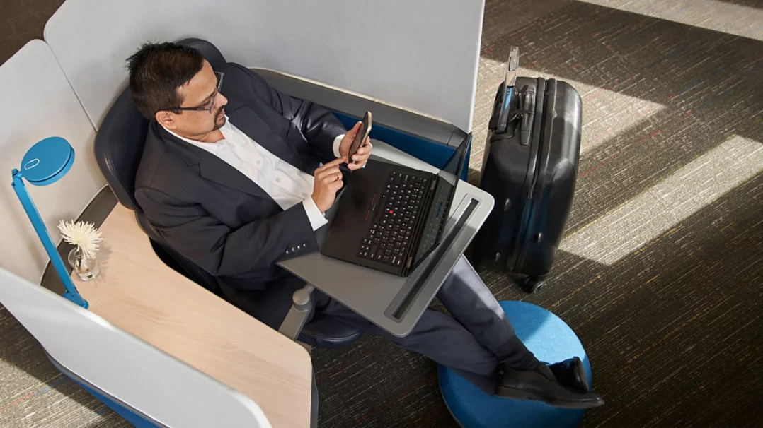 Un homme sur une chaise travaille sur un ordinateur portable