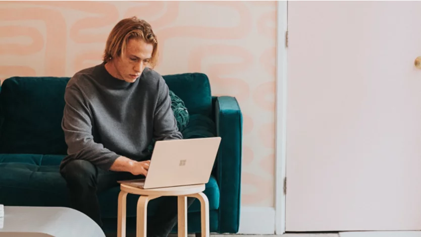 A man using a Microsoft Surface Laptop 3 in the sandstone color