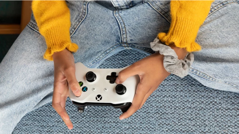 A person using a wireless Xbox controller