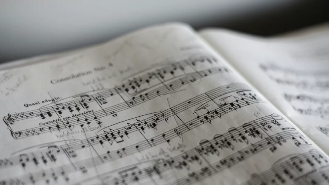 An open book of sheet music with notes written in pencil