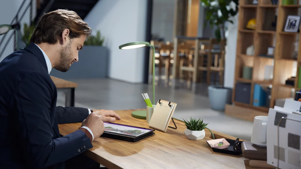 Mand, der sidder ved et skrivebord og arbejder på sin computer