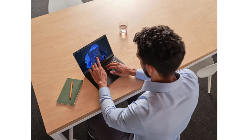 A person touching the screen of a Windows Surface Pro in laptop mode