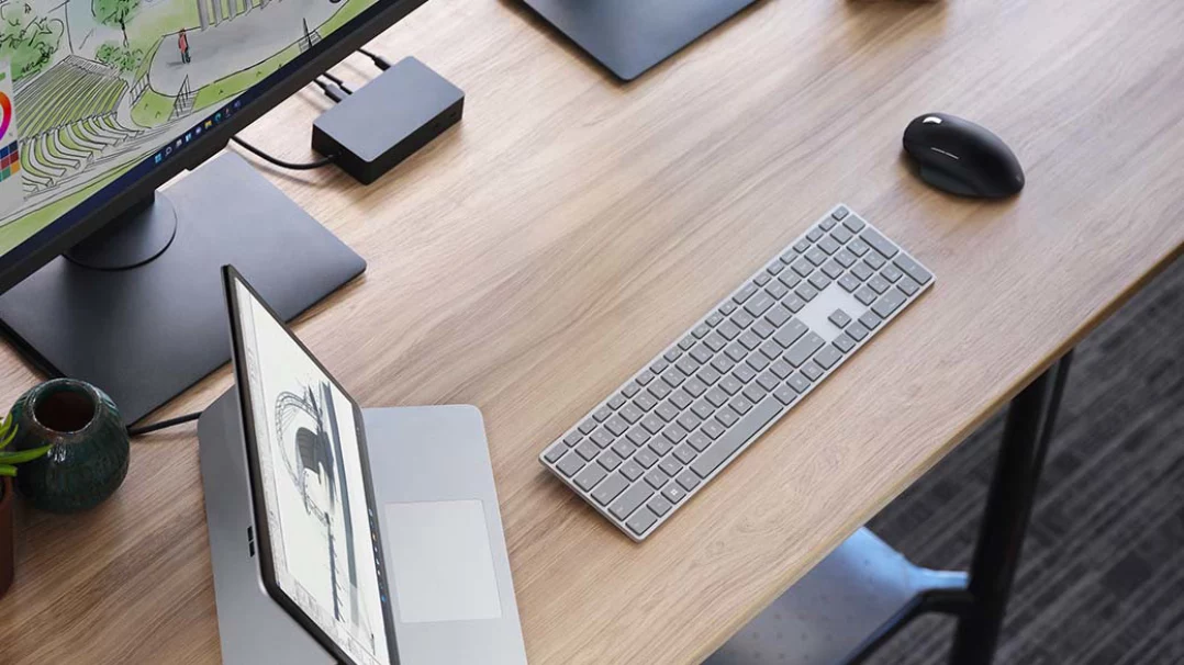 Un dispositivo Surface Laptop Studio con vari accessori sulla scrivania di un ufficio