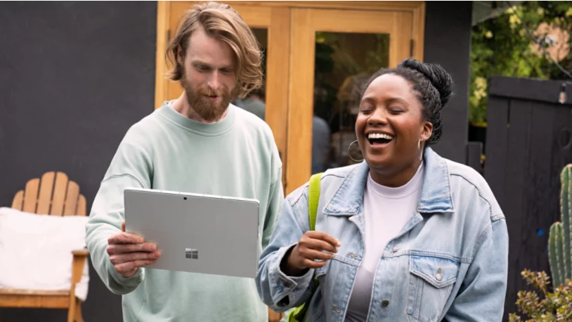 Two people using a Surface Pro 9 with 5G while outside