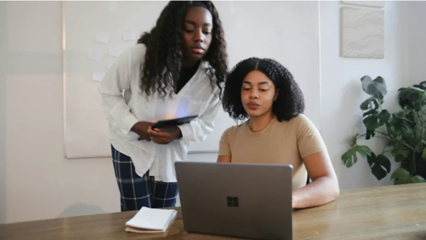 Two women collaborating on a Microsoft Surface laptop