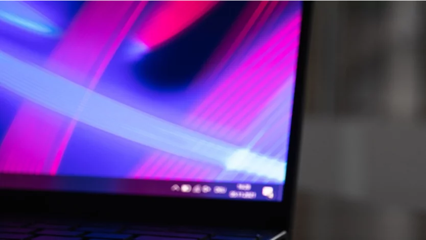 Windows laptop in a dark setting with a colorful background
