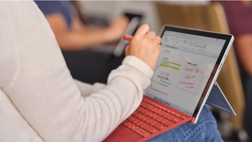 student using laptop in classroom