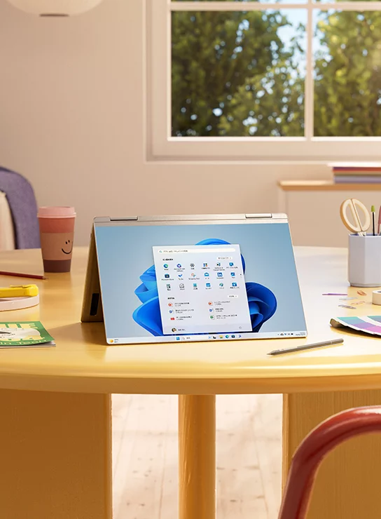 机の上に折り畳んだ状態で開かれた Windows 11 デバイス