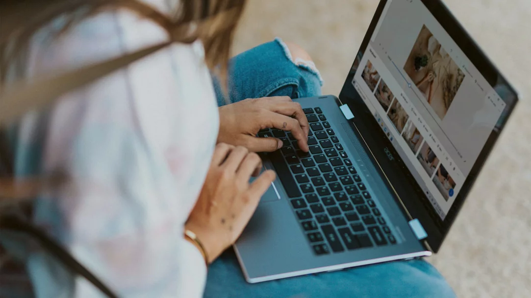 Woman in white long sleeve shirt using laptop