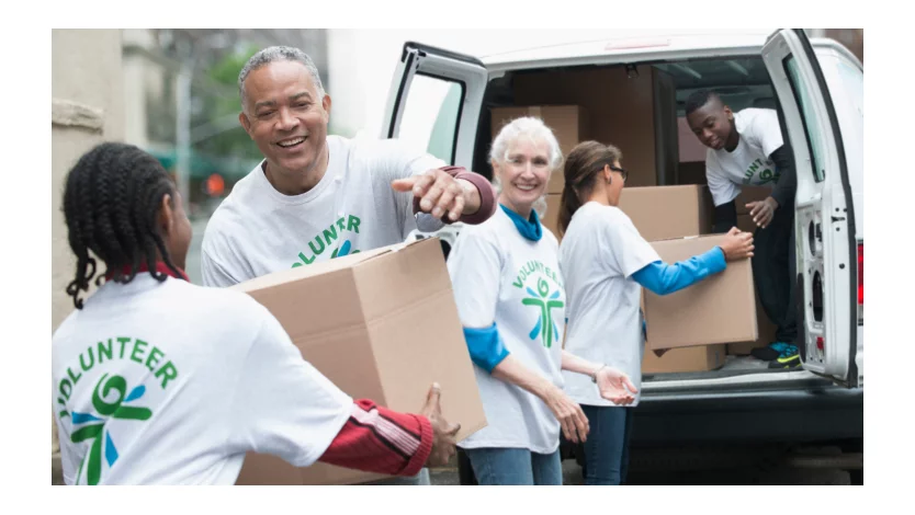 Un grupo de voluntarios saca cajas de cartón de una furgoneta.