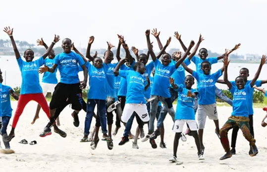 Children wearing Unicef t-shirts jumping