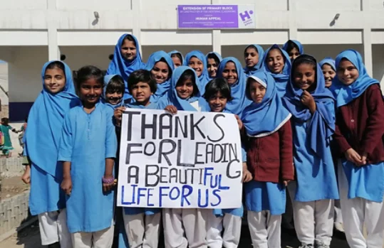 Un grupo de niños en la calle lleva una pancarta en la que dice Gracias por darnos una buena vida