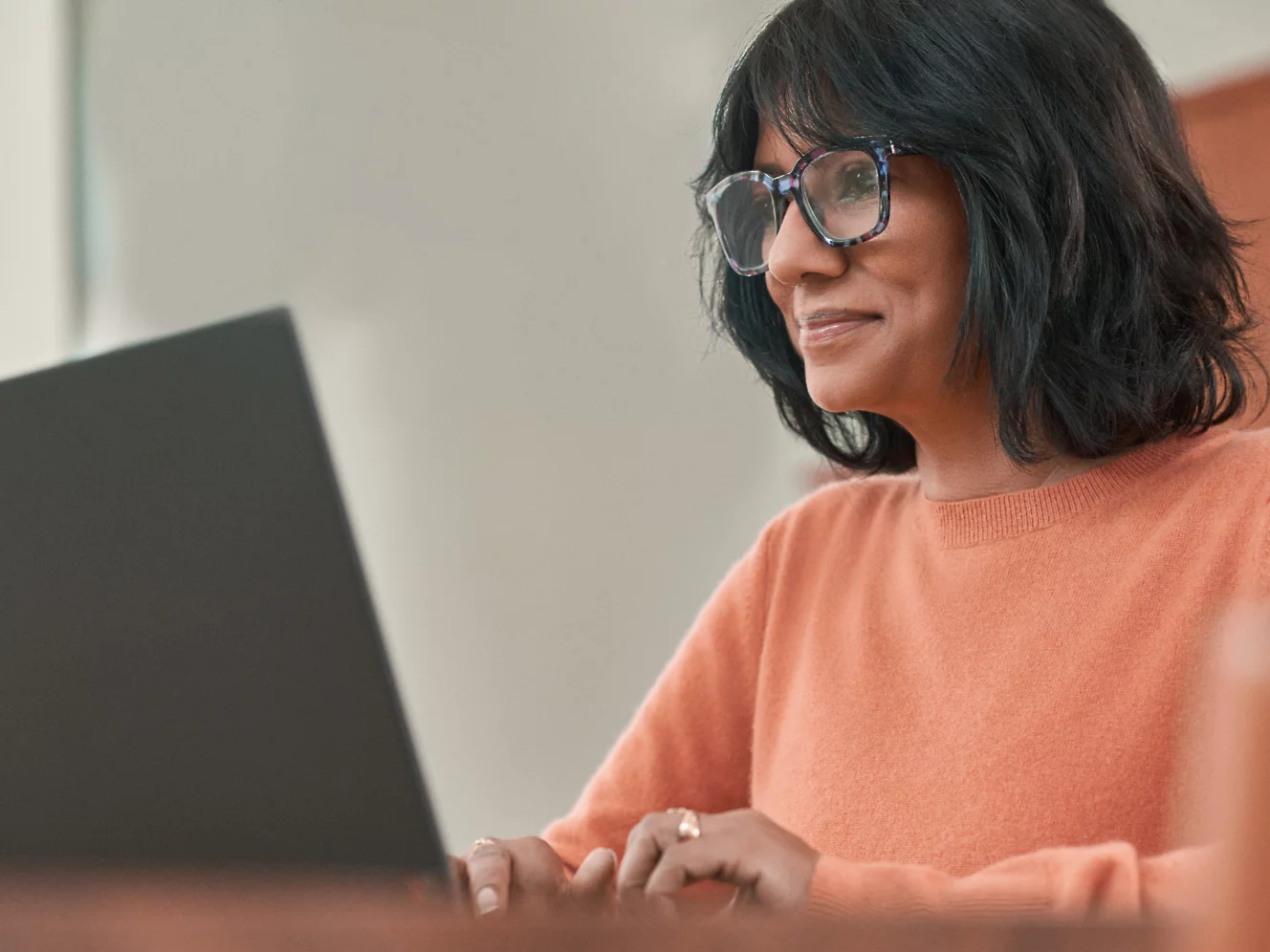 A woman with spectacles working with laptop