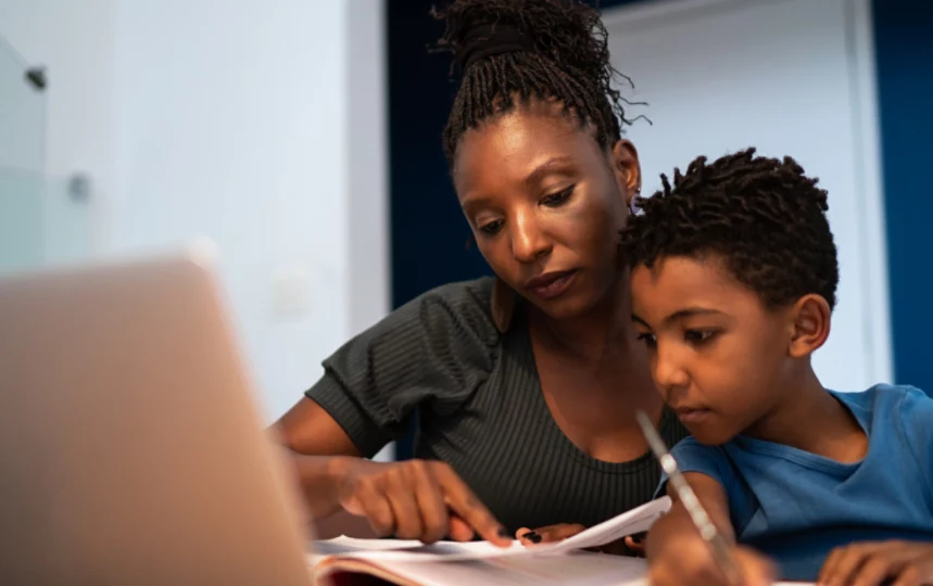 Mother helping son with homework at home.