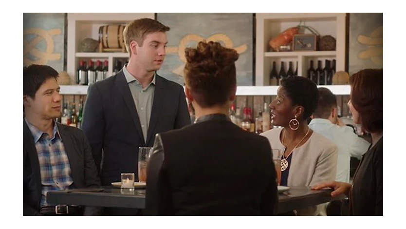 Five characters from the SBC training video at a table in a bar having a conversation.