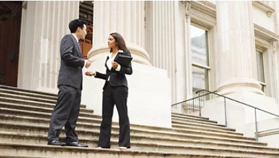 Two people talking in front of a building