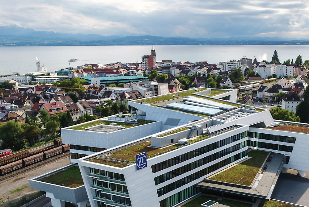 Un edificio grande con un techo verde con el logotipo de ZF