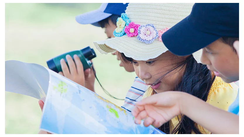 3人の子供が地図を見ている