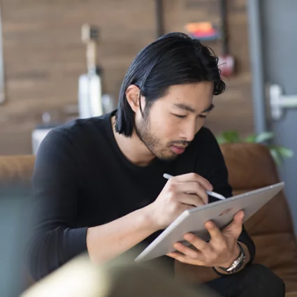 Un uomo che tiene un PC e utilizza una penna digitale