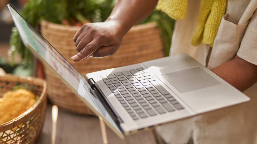 A person holding a laptop using touchscreen gestures