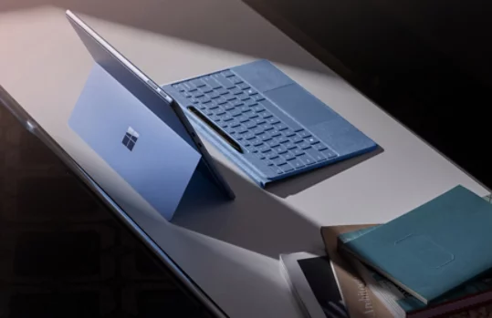 取り外された Surface Pro Flex Keyboard やスリム ペンと一緒にデスクの上に置かれた Surface Pro (カラー: サファイア)。