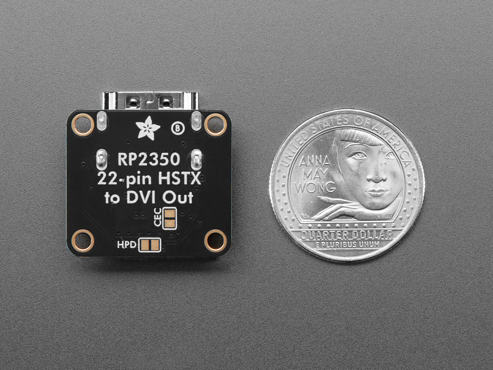 Back of black square-shaped breakout board next to US Quarter for scale.