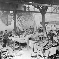 Workmen constructing the Statue of Liberty in Frederic Auguste Bartholdi's Parisian warehouse workshop; first model; left hand and quarter-sized head. Photo by Albert Fernique, ca. 1882-83.