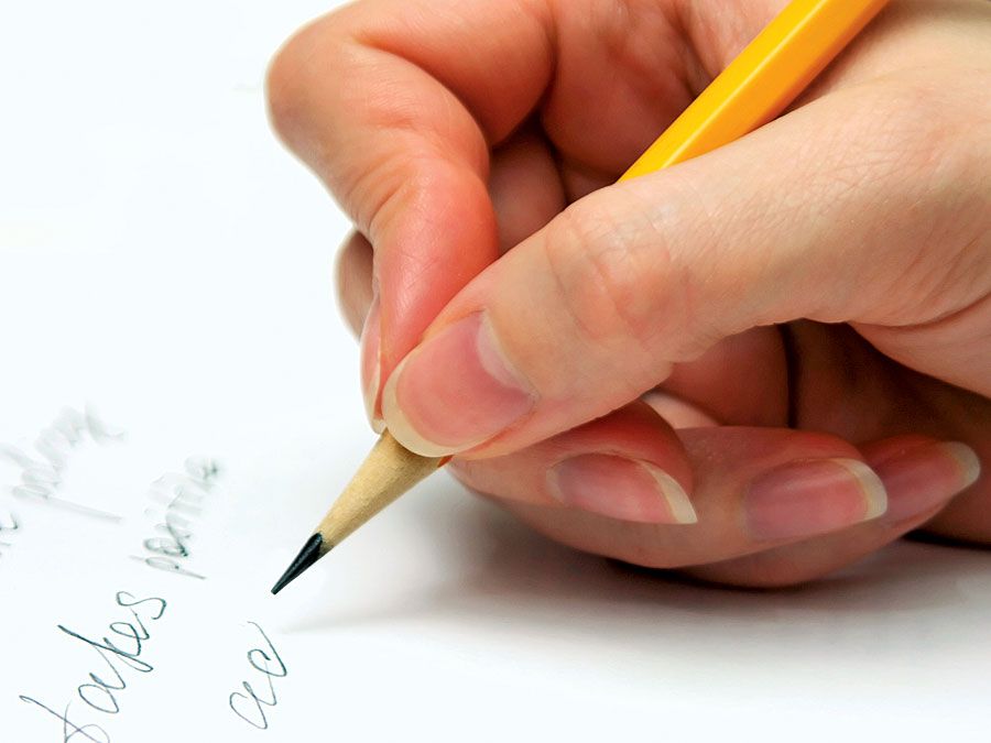 Hand with pencil writing on page. (handwriting; write)