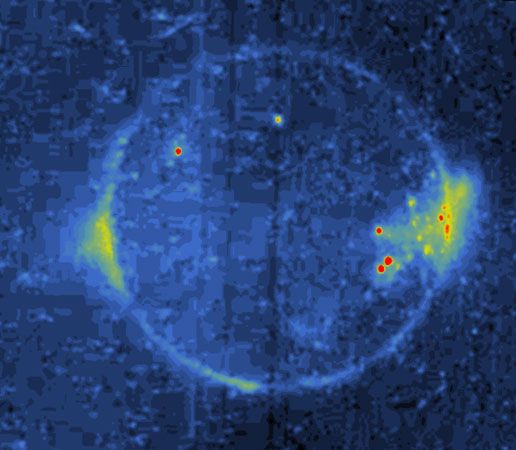 Io, in Jupiter's shadow, photographed by the Galileo spacecraft on May 6, 1997. The relative brightnesses of Io's features are enhanced with added colour, red being the most intense, yellow-green moderate, and blue the faintest. Small red and yellow-green spots are probably lava flows or lakes, while the bright area extending from Io's left limb corresponds to the plume from the volcano Prometheus. The diffuse glow on the right limb also has plumelike characteristics.