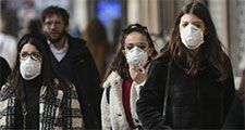 People wearing surgical masks (also called face mask or medical masks or safety masks) walk through the city center of Milan, Italy on Feb. 23, 2020. Coronavirus disease COVID-19 pandemic