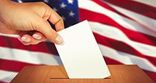 Close up of a hand placing a ballot in a ballot box. Election vote voter voting