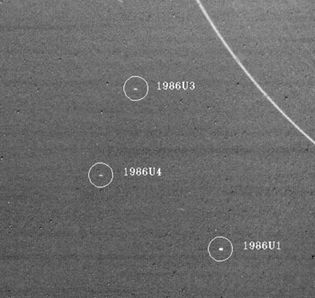 Three of the satellites of Uranus discovered by the Voyager 2 spacecraft are shown in an image taken Jan. 18, 1986.The largest of the satellites, 1986U1 (lower right), is about 90 km (55 miles) in diameter. In the upper right is the outermost ring of Uranus.