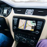 In Frankfurt, Germany, a driver uses a car GPS infotainment display system to guide them on a German autobahn. lanes; traffic; navigation; travel; map