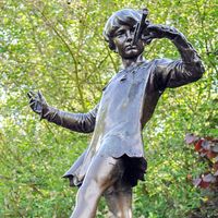 The Peter Pan statue in Kensington Gardens. The statue shows the boy who would never grow up, blowing his horn on a tree stump with a fairy, London. fairy tale