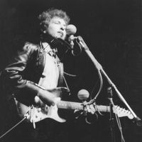 Bob Dylan plays a Fender Stratocaster electric guitar for the first time on stage as he performs at the Newport Folk Festival on July 25, 1965 in Newport, Rhode Island.