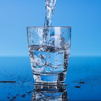 Drinking water is poured into a glass.