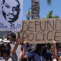 Oceanside, CA / USA - June 7, 2020: People hold signs during peaceful Black Lives Matter protest march, one of many in San Diego County. One sign reads "Defund Police"