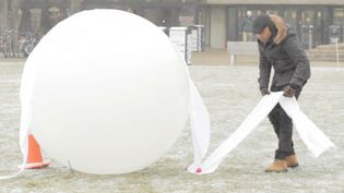 See students making various shell structures of frozen fabric made out of ice and fabric